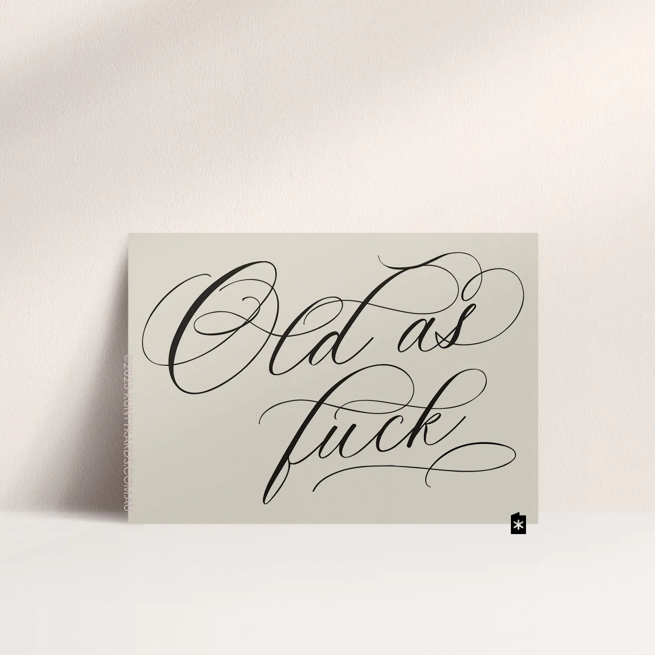 Grey card with black ink printed in script font on the front that says "Old as fuck" made in Perth WA by Kunty Kards